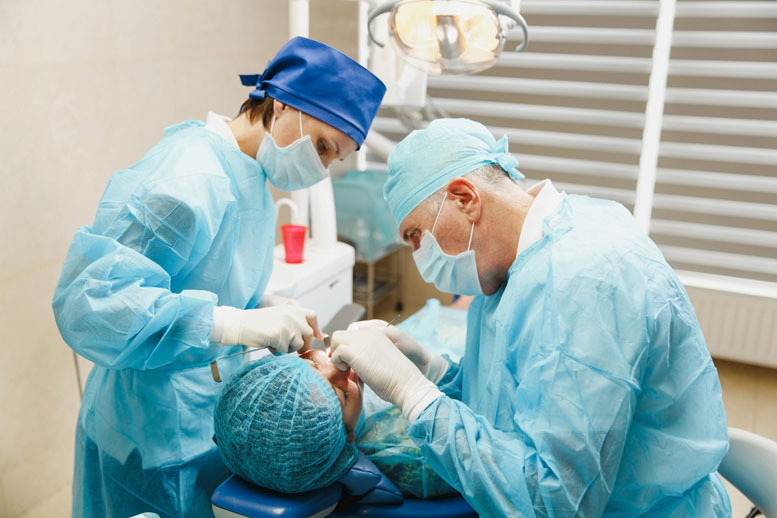 Dentists performing a dental implant